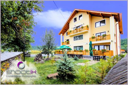 a building with tables and chairs in front of it at Camves Inn in Sighetu Marmaţiei