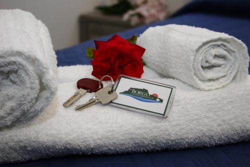 a bunch of towels with a key and a flower at Il Borgo in Castelsardo