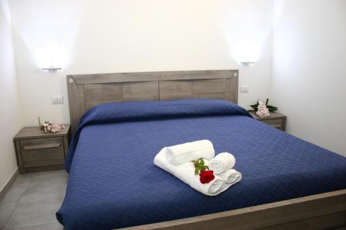 a bedroom with a blue bed with two towels at Il Borgo in Castelsardo