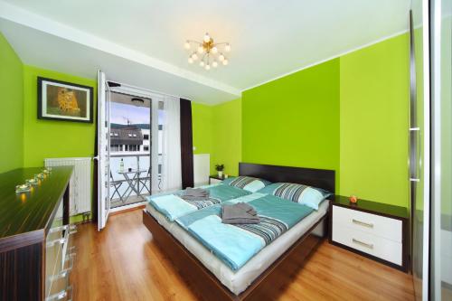 a green bedroom with a bed and a window at Apartment 91/65 Špindlerův Mlýn in Špindlerův Mlýn
