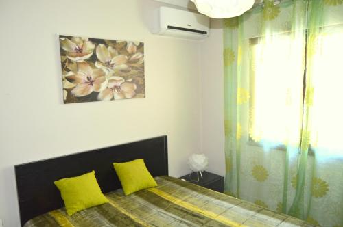 a bedroom with a bed with two yellow pillows at Apartamento Glamour in Manta Rota