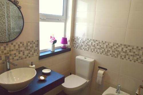 a bathroom with a sink and a toilet and a mirror at Apartamento Glamour in Manta Rota