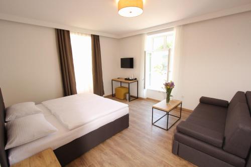 1 dormitorio con 1 cama y 1 sofá en Riverside Residence en Sarajevo