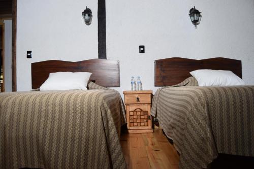 two beds sitting next to each other in a bedroom at Campestre DAARLU in Huauchinango