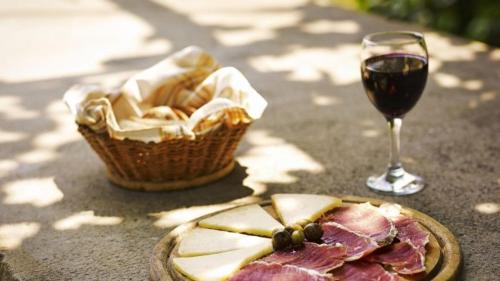 a glass of wine next to a basket of food and a plate of meat at Floating Sea Houses MARINA LUX in Portorož
