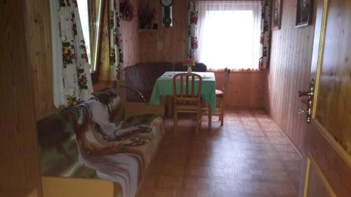 a room with a table and a person sitting on a couch at Haus Kerschbaumer in Rangersdorf