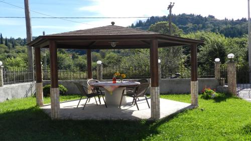a gazebo with a table and chairs in a yard at Filoxenia Kontogiannis in Lazaráta