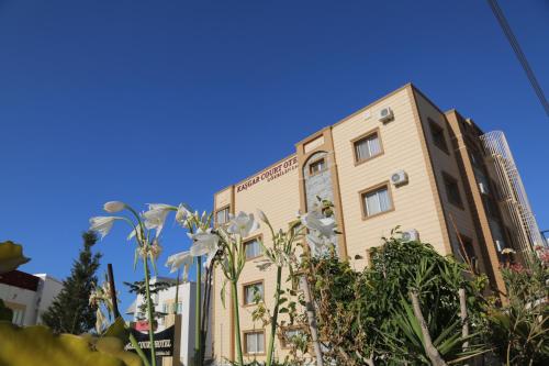 a building with white flowers in front of it at Kasgar Court Hotel in Karaoğlanoğlu