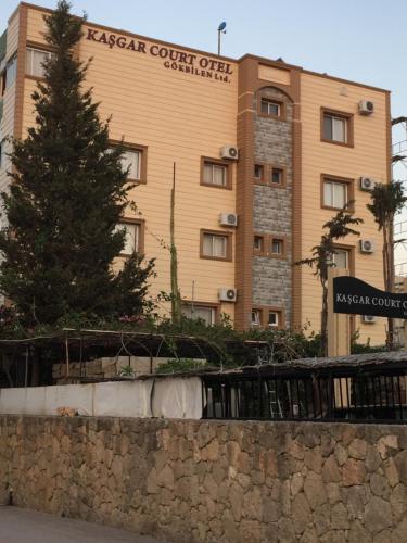 a building with a christmas tree in front of it at Kasgar Court Hotel in Karaoğlanoğlu