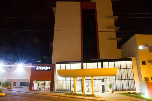 an empty parking lot at night with a building at Lindóya Hotel in Catalão