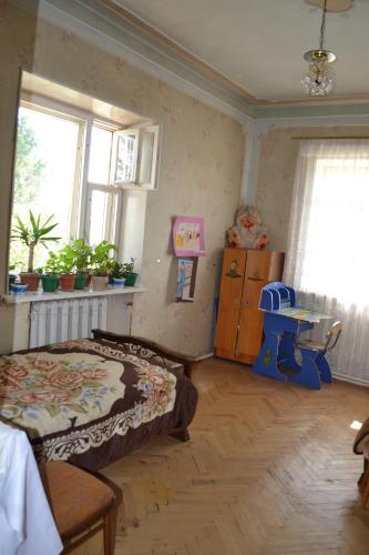 a bedroom with a bed and a table and windows at Serik & Geora Guesthouse in Sevan