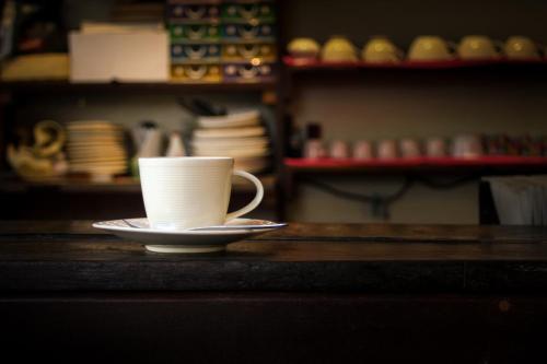 a coffee cup on a plate on a table at Lamphuhouse Bangkok in Bangkok
