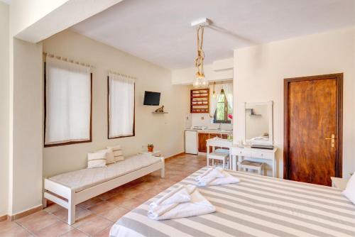 a bedroom with a bed and a couch and a desk at Anemologio in Finikas