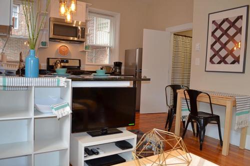 a living room with a large television and a kitchen at Gorgeous 2 bed best North End location w parking in Boston