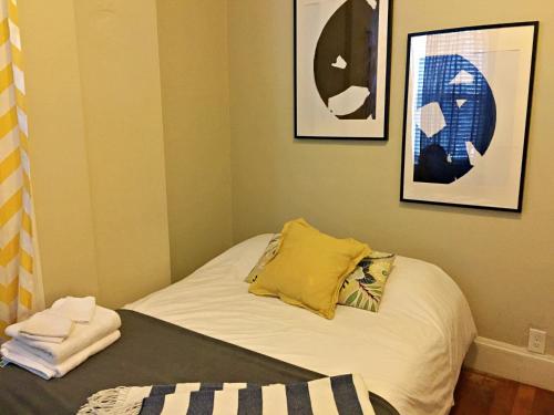 Cama pequeña en habitación con cuadros en la pared en Gorgeous 2 bed best North End location w parking en Boston