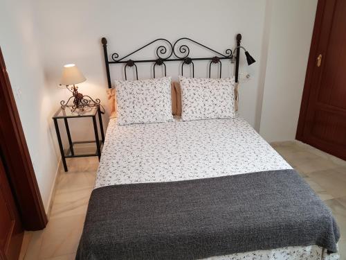 1 dormitorio con 1 cama grande con marco negro en Fan Flat Rosaleda, en Málaga
