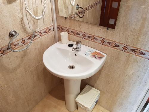 y baño con lavabo blanco y espejo. en Fan Flat Rosaleda, en Málaga