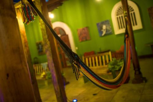 a green room with a hammock in a room at El Caite Hostel in Granada