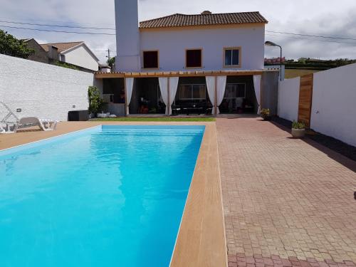 a swimming pool in front of a house at Casa do Sossego - Guesthouse in Rabo de Peixe