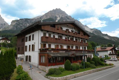 a building on the side of a street with a mountain at Hotel Albergo Dolomiti in San Vito di Cadore