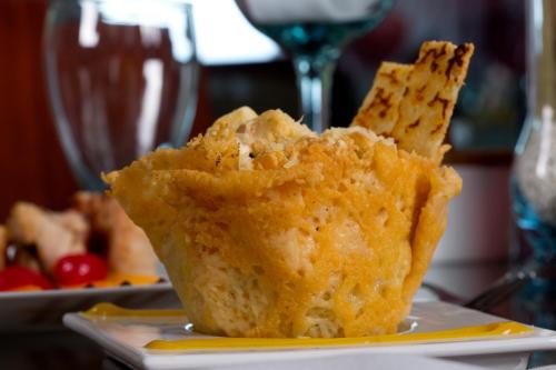 a muffin sitting on a plate with a glass of wine at Atlantis Plaza Hotel Cúcuta in Cúcuta