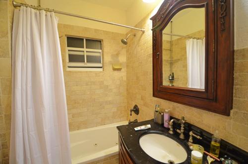 a bathroom with a sink and a mirror and a tub at Magical villa -Private pool-spa & garden in Lake Worth