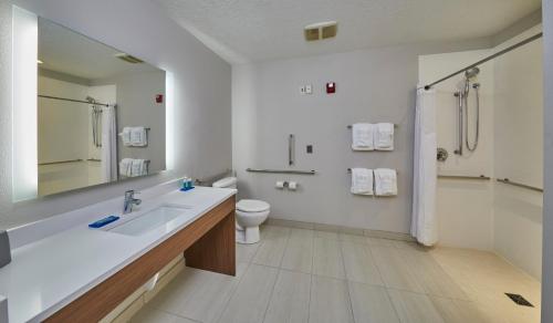 ein Badezimmer mit einem Waschbecken, einem WC und einem Spiegel in der Unterkunft Holiday Inn Express Hotel & Suites Medford-Central Point, an IHG Hotel in Central Point