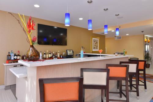 a bar in a hotel room with a tv on the wall at Best Western Plus Fresno Airport Hotel in Fresno