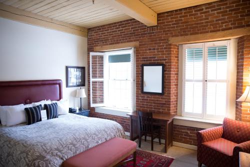 a bedroom with a bed and a brick wall at The Common Man Inn & Restaurant in Claremont