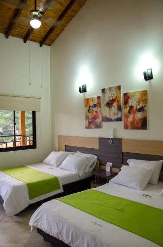 una camera da letto con due letti e una finestra di Hotel La Montaña San Gil a San Gil
