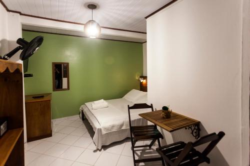 a bedroom with a bed and a table and chairs at Pousada Quatro Estacoes in Trindade
