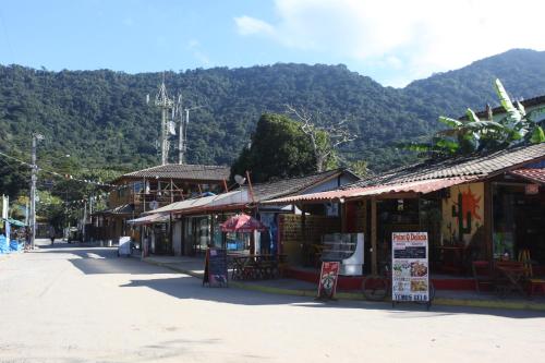 a group of shops on a street with a mountain at Pousada Quatro Estacoes in Trindade