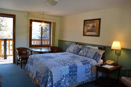 a hotel room with a bed and a table and chairs at Kancamagus Lodge in Lincoln