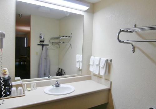 a bathroom with a sink and a large mirror at Country Hearth Inn & Suites Dawson in Dawson