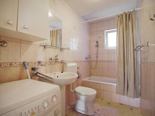 a bathroom with a sink and a toilet and a tub at Apartments Barbara in Banj