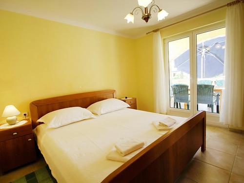 a bedroom with a large bed with two towels on it at Apartments Barbara in Banj