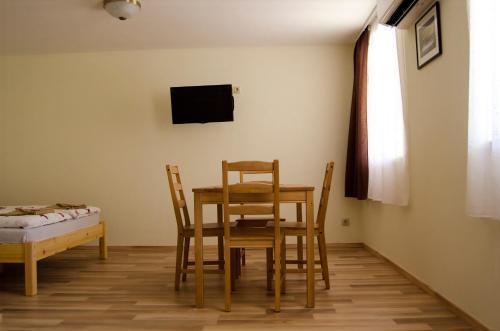 a dining room with a table and chairs and a television at CSONGRÁDI VENDÉGVÁRÓ Apartmanok, Szarka ház in Csongrád
