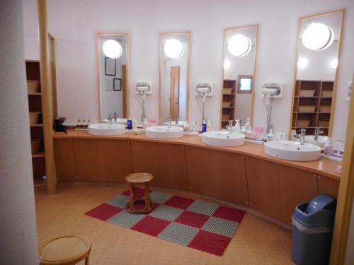 a bathroom with four sinks and two mirrors at Kagetsuen in Hakone