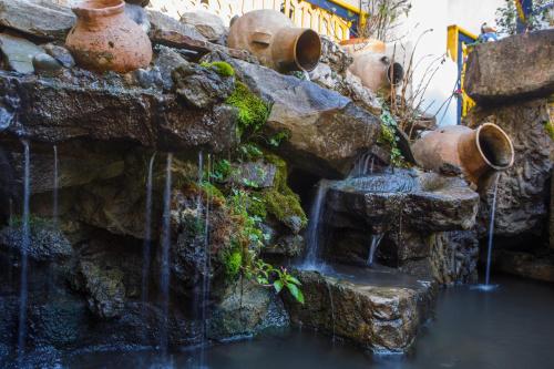 a waterfall in a stone wall with water coming out of it at Hotel Museo la Posada del Molino in El Cocuy