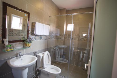 ein Bad mit einem WC, einem Waschbecken und einer Dusche in der Unterkunft Redhouse Dalat Hotel in Da Lat