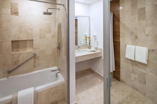 a bathroom with a shower and a tub and a sink at Hotel Villa Varadero in Nuevo Vallarta 