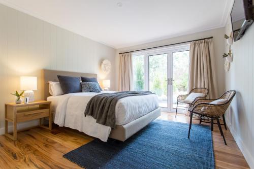 Un dormitorio con una cama y una ventana grande. en Haven Red Hill, en Red Hill