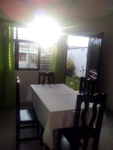 a bedroom with a bed and two chairs and a window at Hotel D'Lina Princess Suites in San Cristóbal de Las Casas