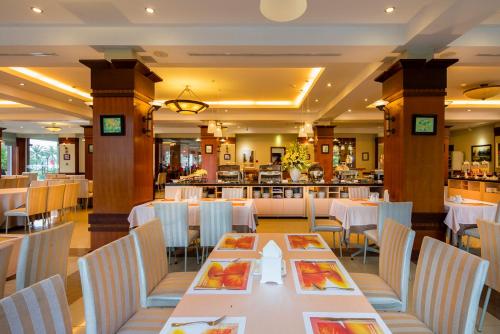 a restaurant with white tables and chairs and a bar at Sai Gon Quang Binh Hotel in Dong Hoi