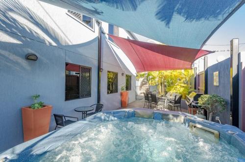 a swimming pool with an umbrella in the middle of the pool at Central Studio Accommodation in Gladstone