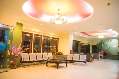 a lobby with chairs and a table and a chandelier at Monaco Dynasty Hotel in Tawau