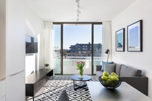 a living room with a couch and a table at Botanik Apartment Hotel in Sydney