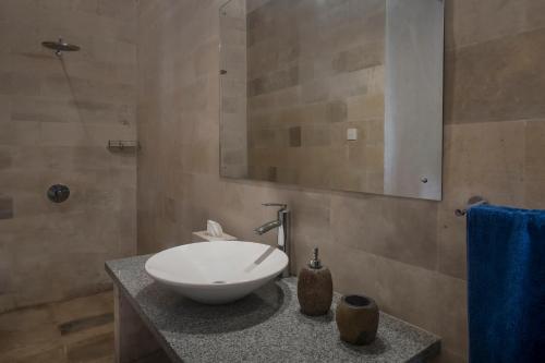 a bathroom with a white sink on a counter at Villa Tepi in Ubud