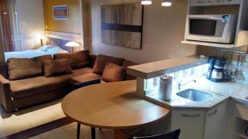 uma cozinha e sala de estar com um sofá e uma mesa em Flat no Hotel Mountain Village em Canela