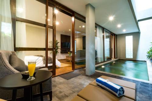 a hotel room with a swimming pool and a bedroom at Aleesha Villas and Suites in Sanur